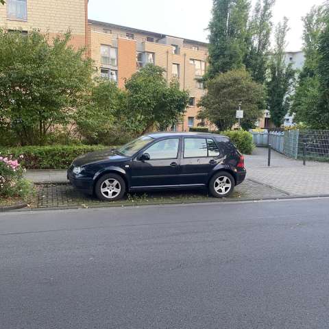 Ein schwarzer VW am Straßenrand 