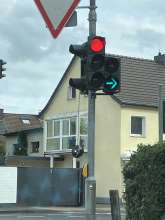 Mittlere Leuchte der Ampel hängt am Kabel heraus und baumelt im Wind.
