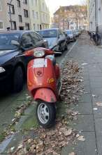 Roter Motor Roller auf Gehweg 
