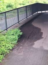 Ein von Schlammablagerungen verunreinigter Weg, der eine große Unfallgefahr durch Rutschen bedeutet.