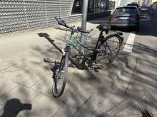 Ein Schrottfahrrad mit verbogenem Rad, platten Reifen und abgebrochenem Licht