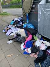 Der Altkleidercontainer quillt über. vom *2025-04-21 09:34:37
