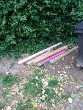 Holzlatten und ein Rollo in einem Karton am Zugang zur Friedensstr. 114/114a