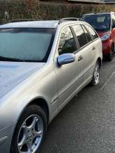 Silberner Mercedes Kombi mit platten Hinterreifen