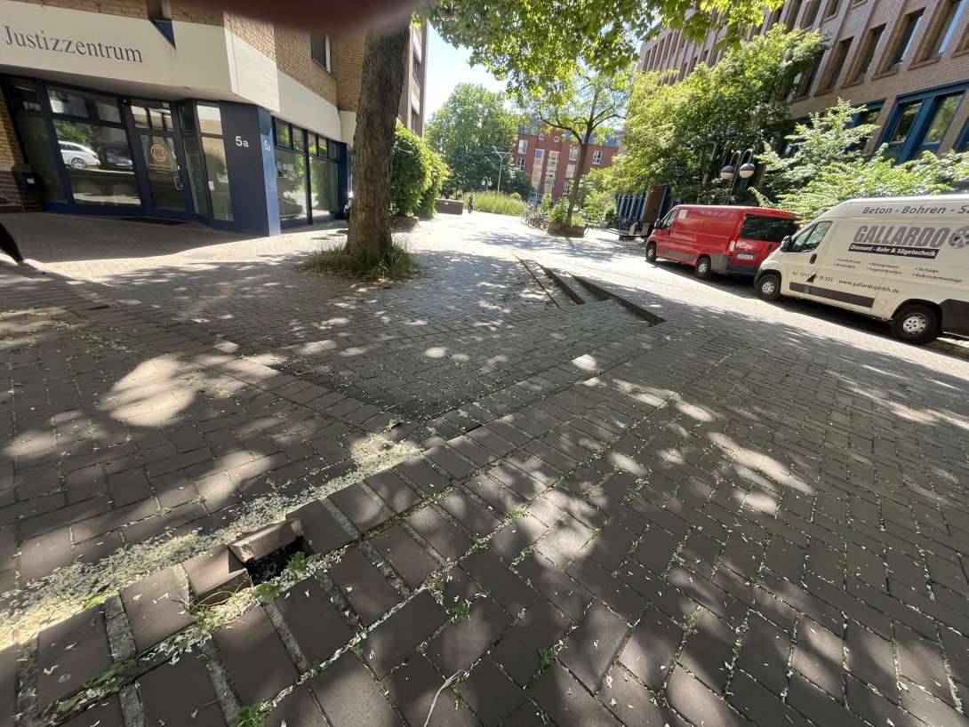 Am Justizzentrum 5a, 50939 Köln : Zwei lockere Gehwegesteine (im Vordergrund des Fotos).