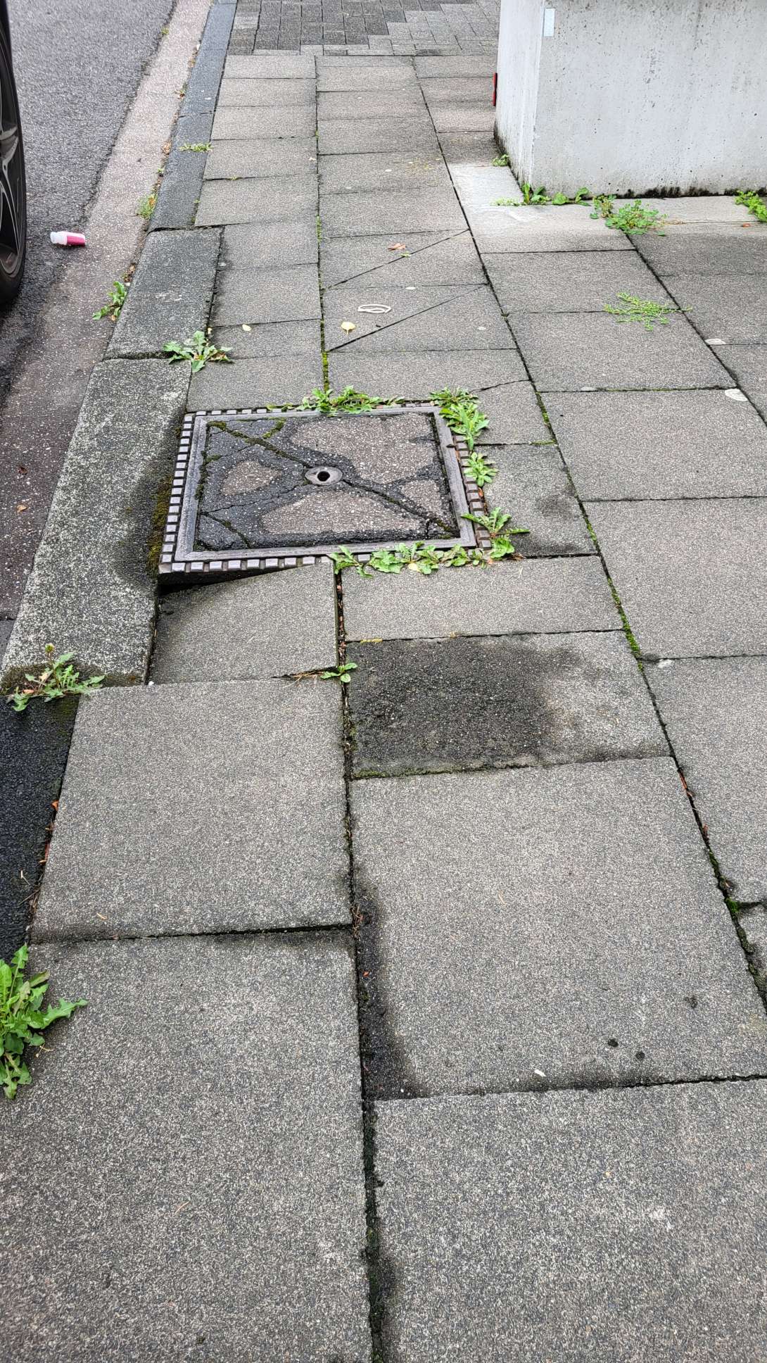 schräg stehende Gehwegplatten neben Kanaldeckel vom *2025-07-31 09:32:16