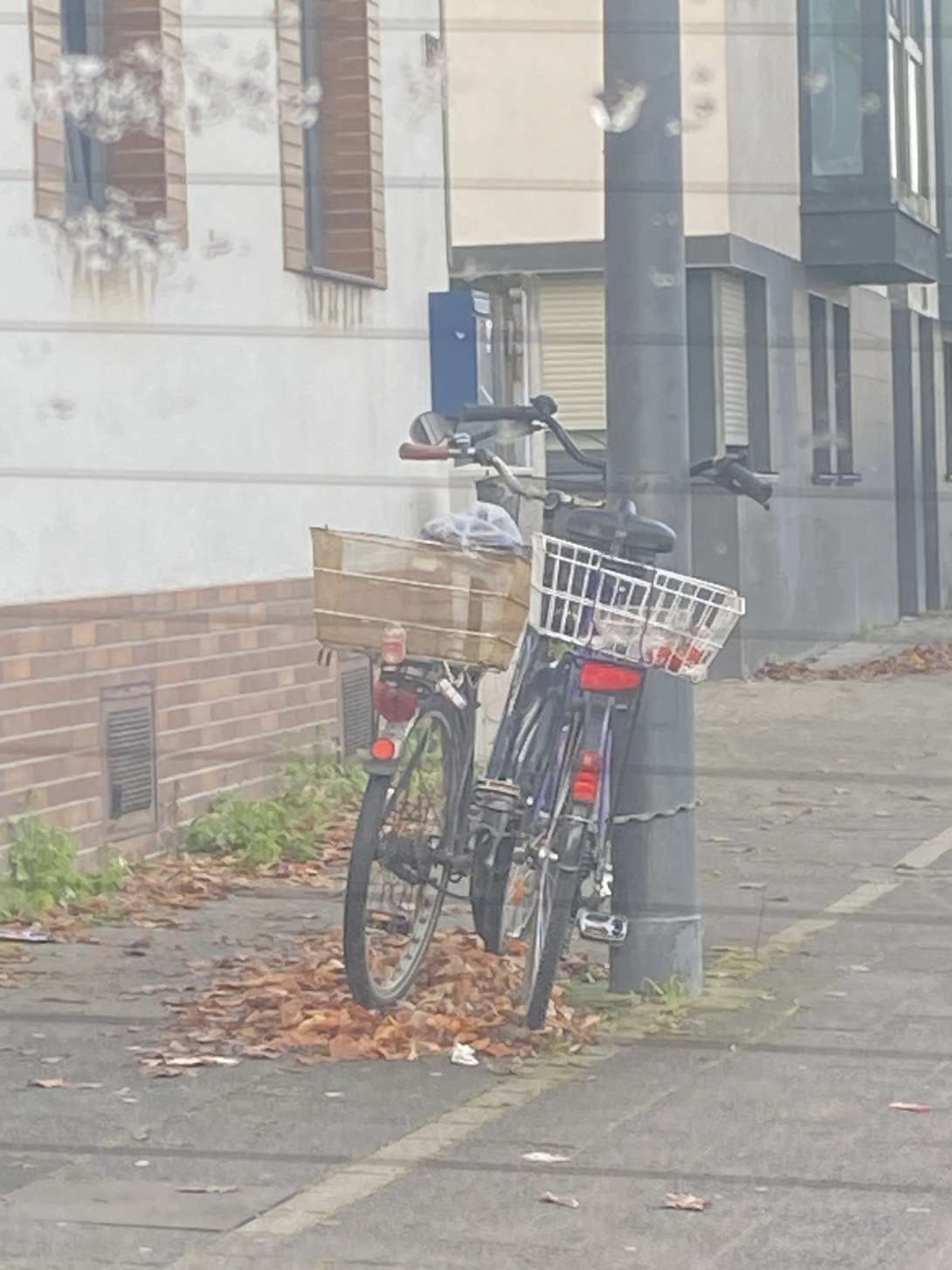 Zwei Schrotträder, die an einer Laternenstange angekettet sind