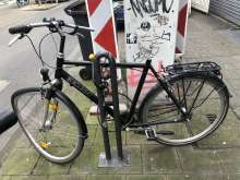 Schwarzes Fahrrad ohne Sattel und mit verbogenem Vorderreifen