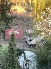 Wilder Müll an der Einfahrt zu der Baustelle bei dem roten Bauzaun