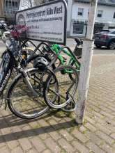 Auf dem Platz vor der Sparkasse gibt es 2 Fahrradstänger: an einem sind 3 Schrottfahrräder, am anderen ist ein loser Schrott-Vorderrad. Bitte bitte entfernen sie alle 4 Schrottobjekte!