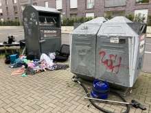 Übervoller Altkleidercontainer und jede Menge wilder Müll