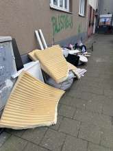 wilder Müll an der Straßenecke, versperrt den Gehweg 