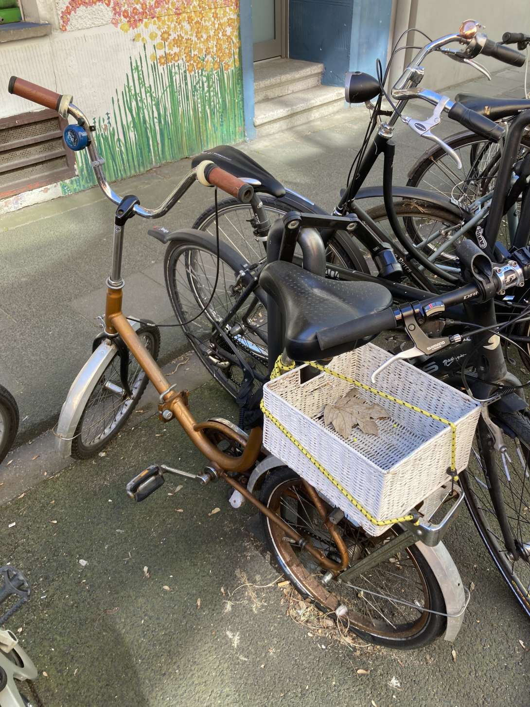 Mehrere Schrotträder in den Fahrradständern vor der Haus Ursulakloster 19