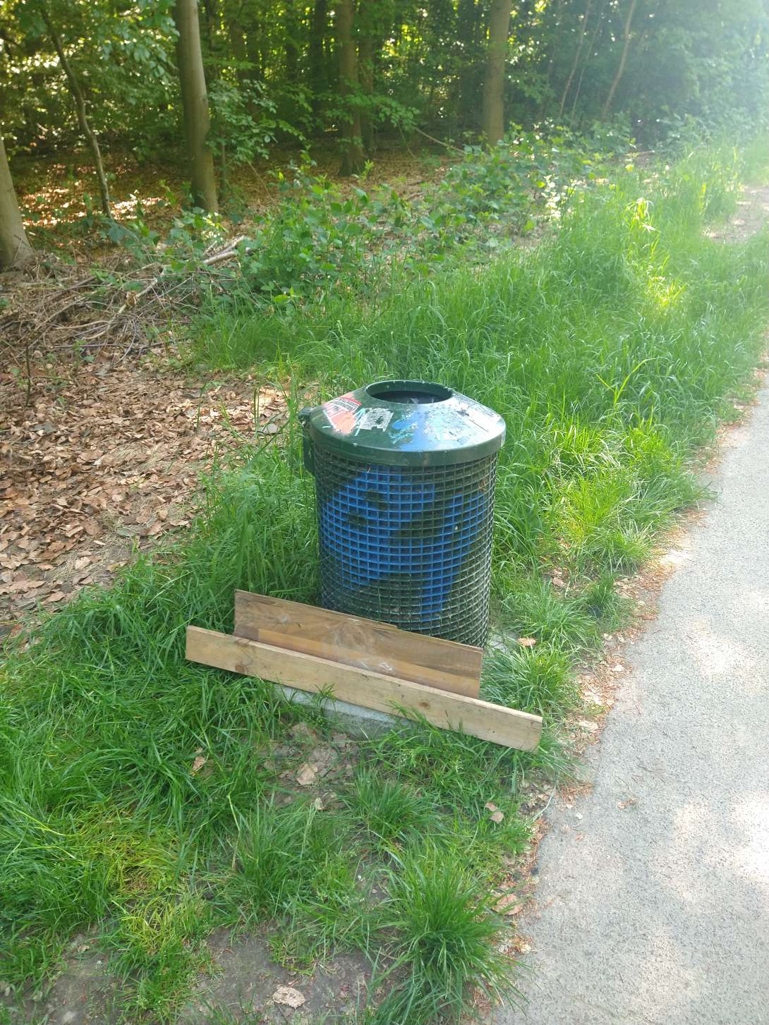 Holzbretter neben Abfallbehälter 'Birkenwäldchen'