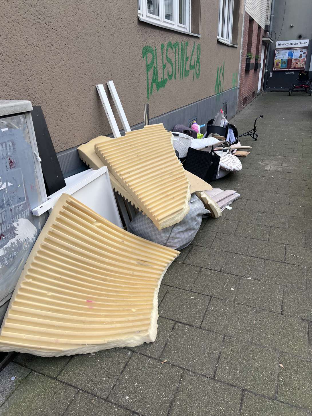 wilder Müll an der Straßenecke, versperrt den Gehweg 